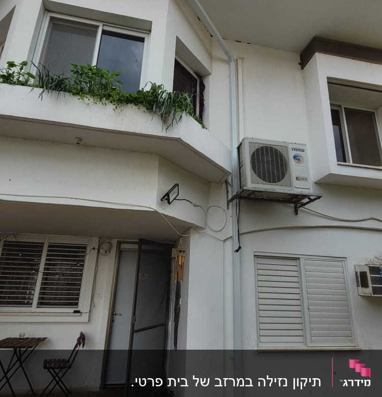 מרזב לבן מחובר לגג הבית